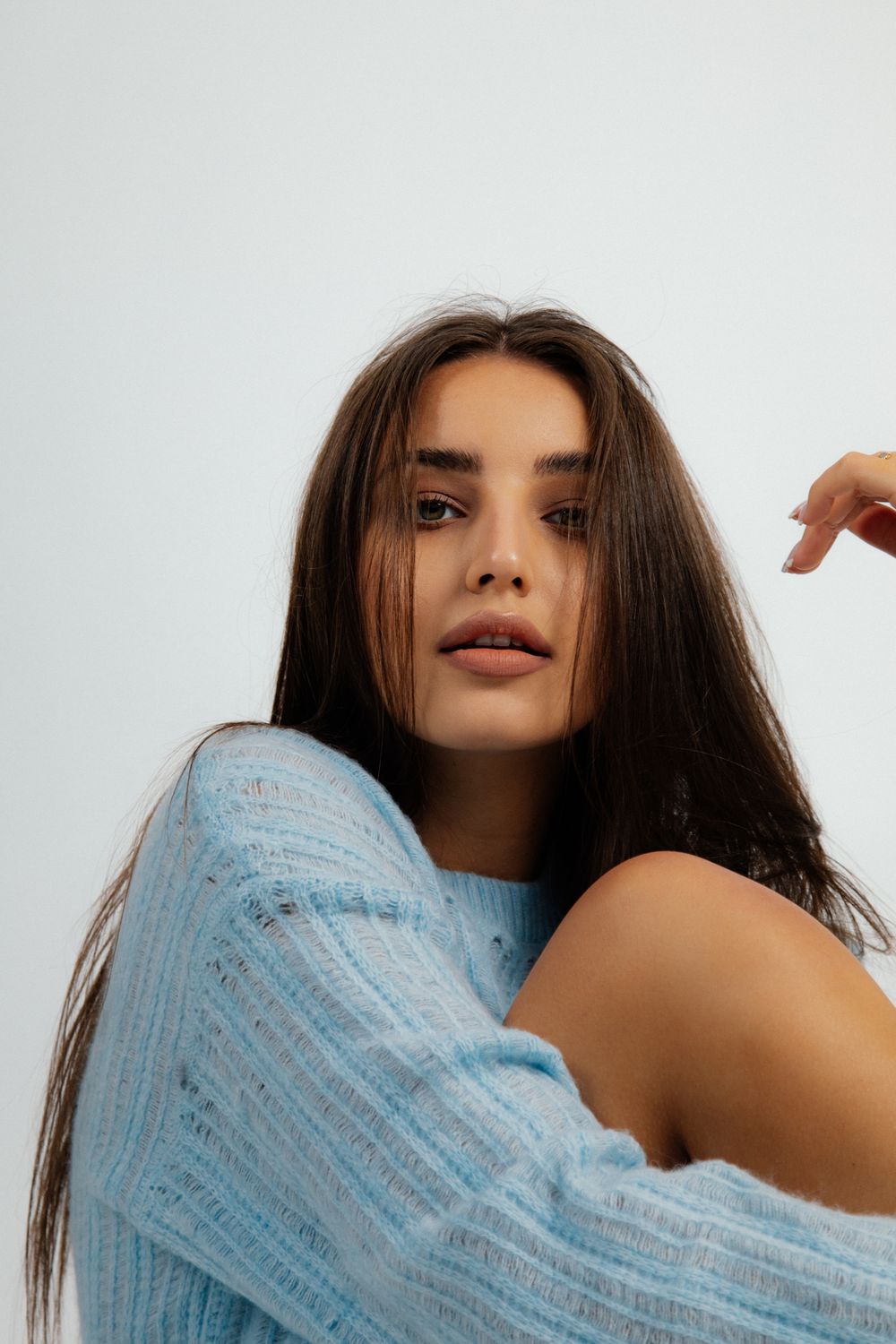 Woman in blue sweater with soft background.